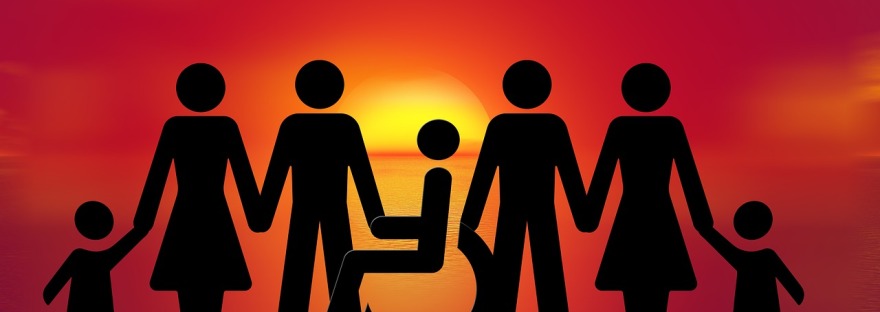 A sunshet shows a family in silhouette. One person sits in a wheelchair